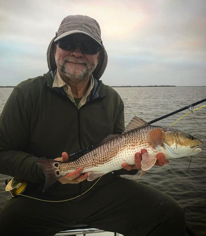 Man holding redfish at the River Fishing Charter in Cocoa Beach