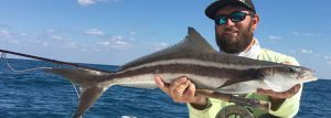 Florida deep sea fishing hacks, man holding large fish with ocean background