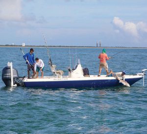10 things to do on space coast of Florida, four men on a boat in the ocean reeling in a fish