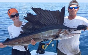 Deep sea fishing Cape Canaveral, couple holding large kingfish on boat with ocean background
