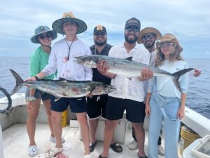 Angler landing a king mackerel during Cocoa Beach deep sea fishing trip