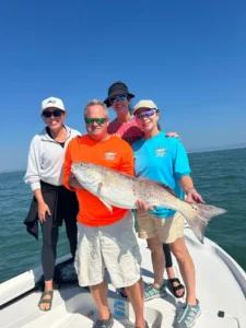 Angler holding a bull redfish during a November Cocoa Beach fishing charter