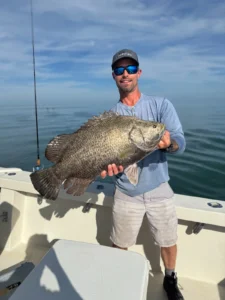 Angler holding a large Tripletail caught off Port Canaveral on a nearshore fishing trip