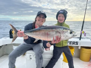 Mother and child holding a blackfin tuna on a deep sea fishing charter near Cape Canaveral Florida